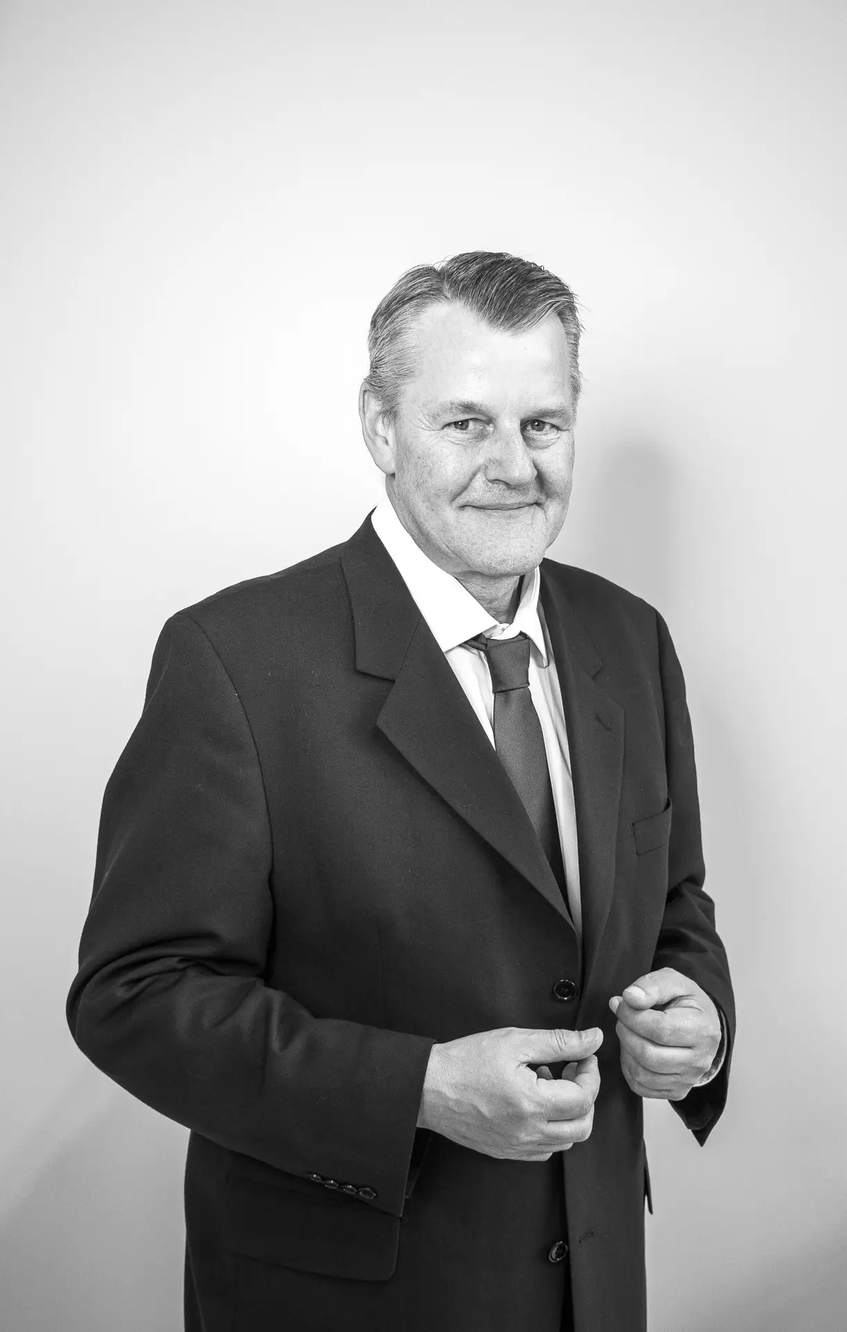 Porträt eines lächelnden Mannes im Anzug, vor neutralem Hintergrund – Herr Markus Burgdorf von Sotheby’s International Realty.