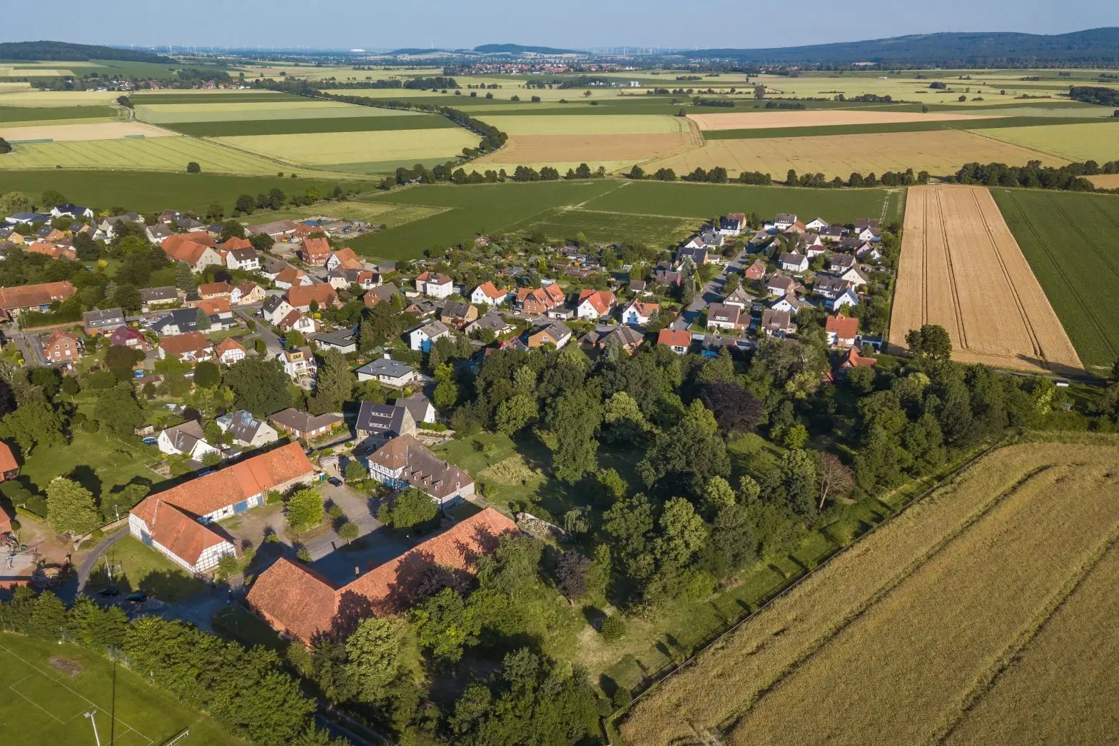 Luftaufnahme von Barsinghausen mit Wohngebiet und Feldern am Deisterrand.