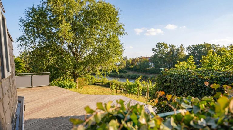 Terrasse mit Blick ins Grüne und auf den angrenzenden Kanal