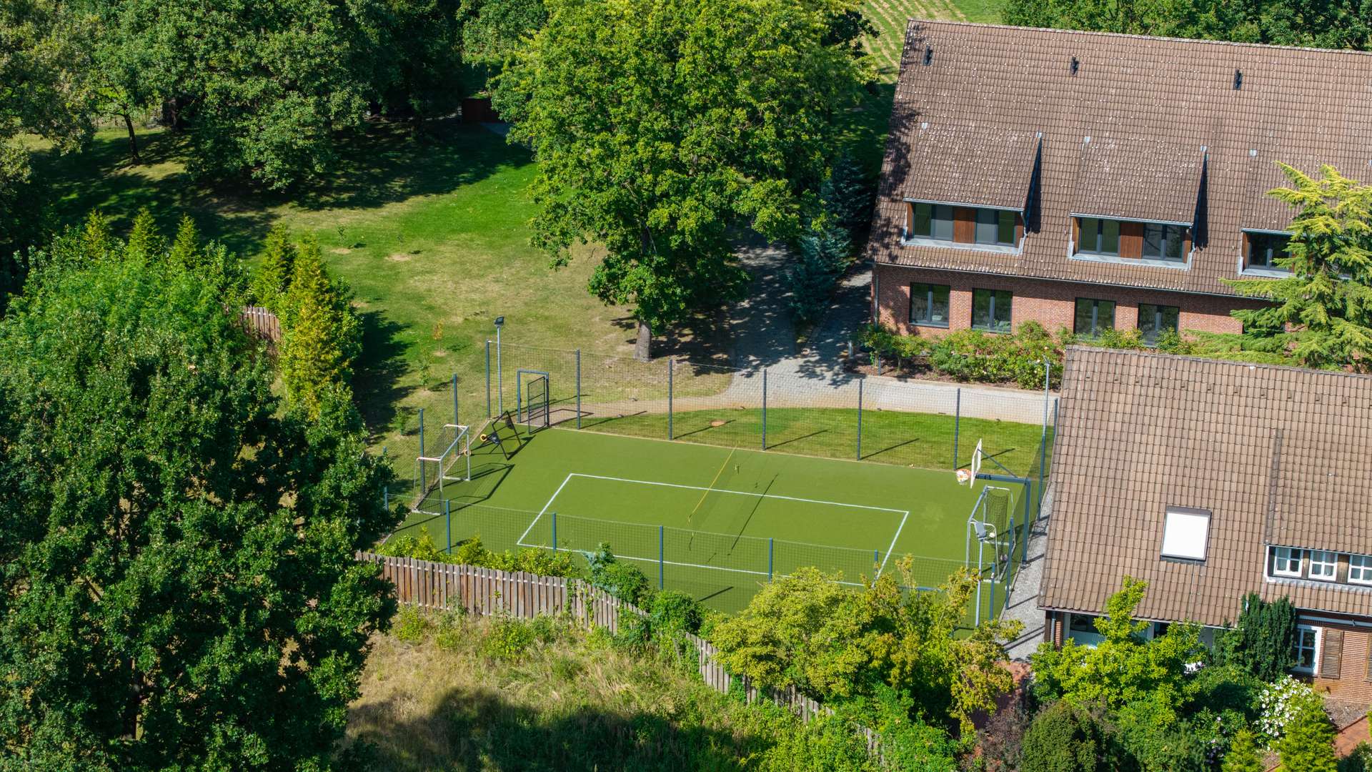 Ein eigener Fußballplatz mit Flutlichtanlage vereinen Wohnen mit Freizeit